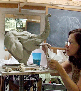 Student sculpting an elephant head in a master Class led by Carter Jones.